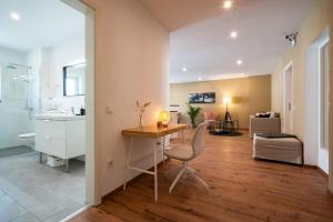 a bathroom with a desk with a chair and a sink at Kaiser9 in Saarbrücken