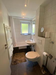 a bathroom with a toilet and a sink and a tub at Steinweg 7 Ferienwohnung in Kassel