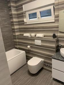 a bathroom with a white toilet and a sink at LUXURY VILLA HELENA in Kaštela