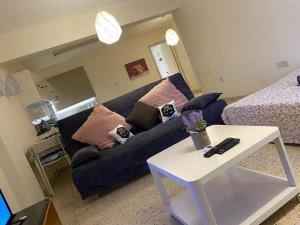 a living room with a blue couch and a bed at Comfort Apartment in Larnaca