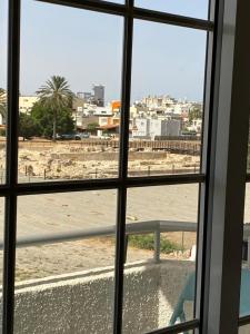 een raam met uitzicht op het strand, dat er doorheen kijkt bij Comfort Apartment in Larnaka