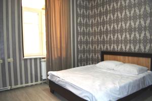 ein Schlafzimmer mit einem Bett, einem Fenster und einer Wand in der Unterkunft MG HOTEL in Yerevan