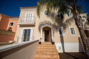 a building with a palm tree in front of it at Boliqueime Villas in Boliqueime