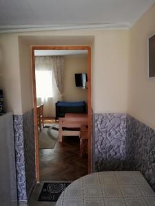 a view of a room with a bed and a living room at Csilla Apartman in Makó