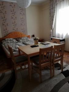 uma sala de jantar com uma mesa e cadeiras e uma cama em Csilla Apartman em Makó