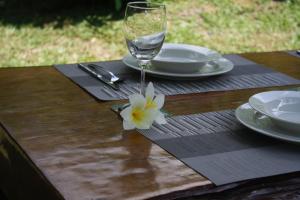 a table with a wine glass and a flower on it at Kuba Bungalows in Ko Kood