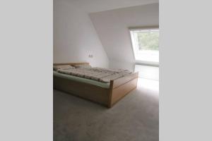 1 dormitorio con 1 cama en una habitación con ventana en Bohmte Zuhause mit Aussicht, en Bohmte
