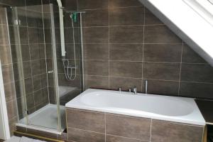 a bathroom with a shower and a bath tub at Bohmte Zuhause mit Aussicht in Bohmte