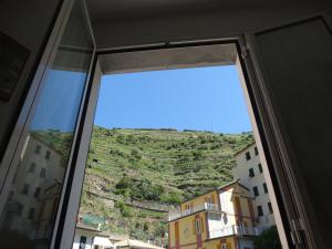 a window in a building with a view of a hill at IRMA Manarola in Manarola
