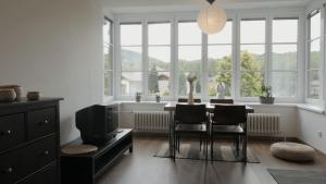 a dining room with a table and chairs and windows at Sola Gratia in Bystřice pod Hostýnem