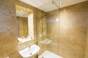 a bathroom with a shower, sink, and mirror at The Mount Hotel Country Manor Wolverhampton in Wolverhampton