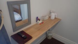 a wooden shelf in a room with a mirror at The Victoria guest house in Mablethorpe