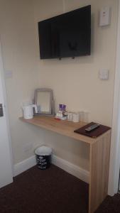 a desk in a room with a television on a wall at The Victoria guest house in Mablethorpe