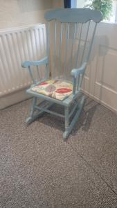a blue rocking chair sitting next to a window at The Victoria guest house in Mablethorpe