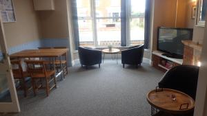 a dining room with a table and chairs and a television at The Victoria guest house in Mablethorpe