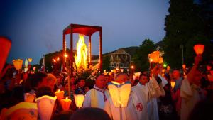 un gran grupo de personas sosteniendo velas en Hotel Calvaire, en Lourdes