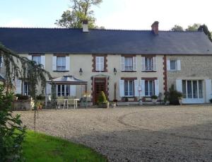 een groot huis met een grindoprit ervoor bij Ferme de Dauval in Mandeville-en-Bessin