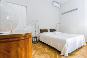 a bedroom with a white bed and a wooden floor at B&B Via Stampatori in Turin