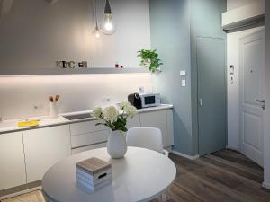 a kitchen with a white table and a vase with flowers at Al Sagraeto in Chioggia