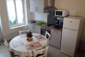 a small kitchen with a table and a white refrigerator at Gite du Domaine de Juliette Location proche du Zoo de Beauval et des Châteaux in Selles-sur-Cher