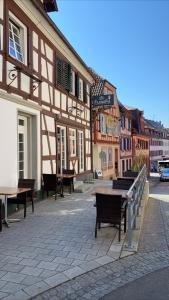 un grupo de mesas y bancos en una calle con edificios en Hotel Löwen, en Lahr