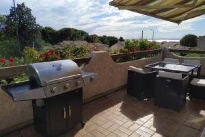 a grill and a barbecue on a patio at Appartement T3 Spacieux avec vue sur l'étang de Thau au 1er étage d'une villa - entrée indépendante in Sète