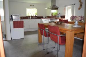 een keuken met een houten tafel en rode stoelen bij Het Zwaluwnest 69 in Giessenburg