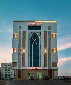 a building with a sign on top of it at Alhattali Hotel in Muscat