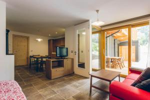a living room with a red couch and a television at Chalet Valcanale in Camporosso in Valcanale