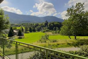 a view of a green field from a balcony at Studio entre lac et montagne in Attignat-Oncin