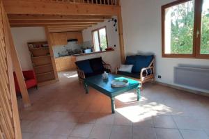 a living room with a table and chairs and a kitchen at Studio entre lac et montagne in Attignat-Oncin