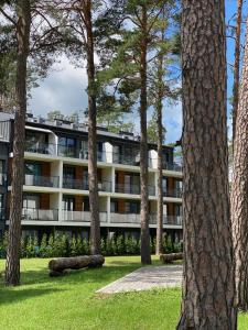 an apartment building with trees in front of it at Apartament Meralia in Augustów