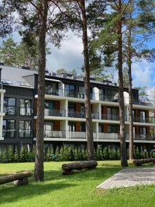 an apartment building with trees in front of it at Apartament Meralia in Augustów
