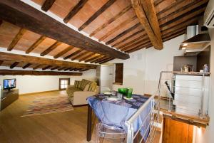 a kitchen and living room with wooden ceilings at Vicolo dell'Oste in Montepulciano +18 photos