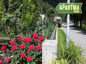 um sinal de rua para um jardim com rosas vermelhas em Apartment Jakelj em Kranjska Gora