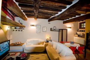 ein Wohnzimmer mit einem Sofa und einem TV in der Unterkunft Vicolo dell'Oste in Montepulciano