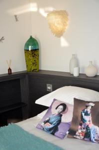 a bedroom with a bed and a vase on the wall at Le Clos Du Lac - location de chambres in Veyrier-du-Lac