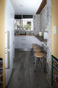 a kitchen with tables and chairs and a refrigerator at Oripando Hostel in Granada