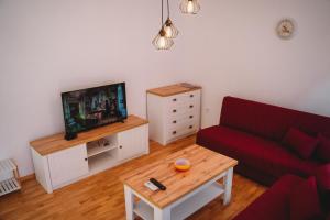 a living room with a red couch and a tv at Andreya's Sea apartment-Beach, Sea garden ,Old Town, Free Parking, Free EVcharging Station in Varna City
