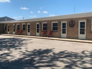 a row of red chairs sitting outside of a building at The Triangle Motel in Alma