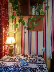 a bed with a lamp and a book on it at "Арбат" Центр квартира- Apartment "Arbat" in Almaty