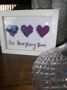 una foto de cuatro corazones púrpura en una caja blanca en The Threshing Barn, en Harrogate