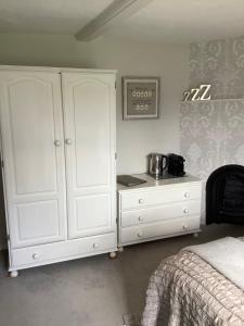 
a bedroom with a bed and a dresser at Birtles Farm Bed and Breakfast in Knutsford
