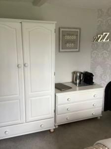 
a kitchen with a white counter top and white cabinets at Birtles Farm Bed and Breakfast in Knutsford
