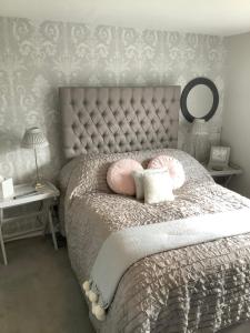 
a bed with a blanket and a pillow on top of it at Birtles Farm Bed and Breakfast in Knutsford
