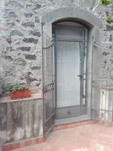 un ingresso a un edificio in pietra con porta in vetro di Bouganville a Catania