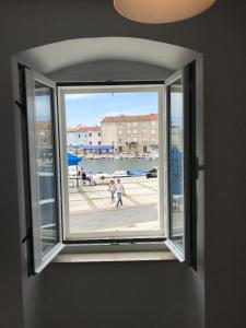 ein Fenster in einem Zimmer mit Hafenblick in der Unterkunft Apartment Pogled na luku II in Cres