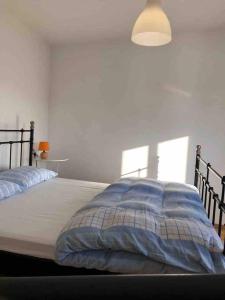 1 Schlafzimmer mit einem Bett mit blauer Decke und 2 Fenstern in der Unterkunft Apartment Pogled na luku II in Cres