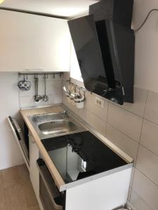 eine kleine Küche mit einer Spüle und einem Herd in der Unterkunft Apartment Pogled na luku II in Cres
