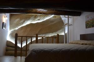 um quarto com uma cama e uma parede de pedra em B&B La Casa Sulla Roccia em Pietrapertosa